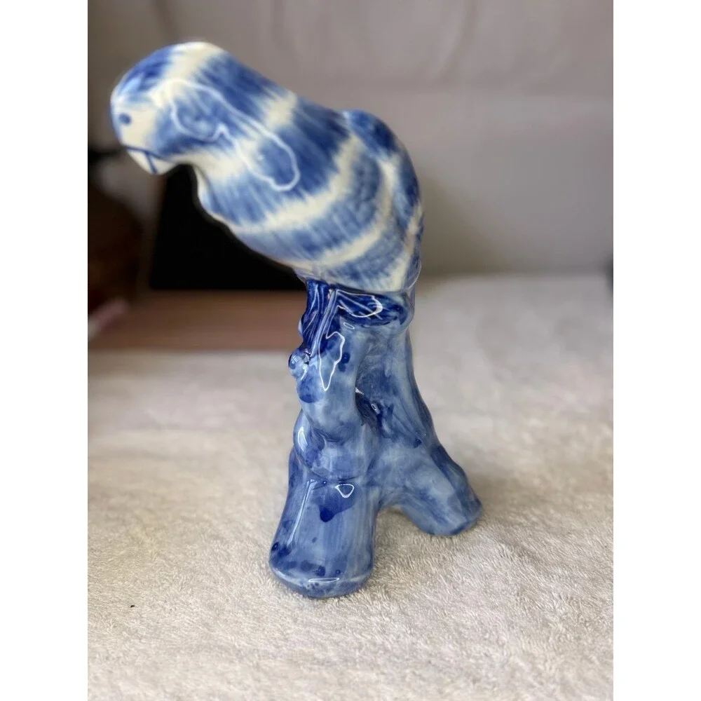Chinoiserie blue and white porcelain parrot figurine, likely hand-painted.